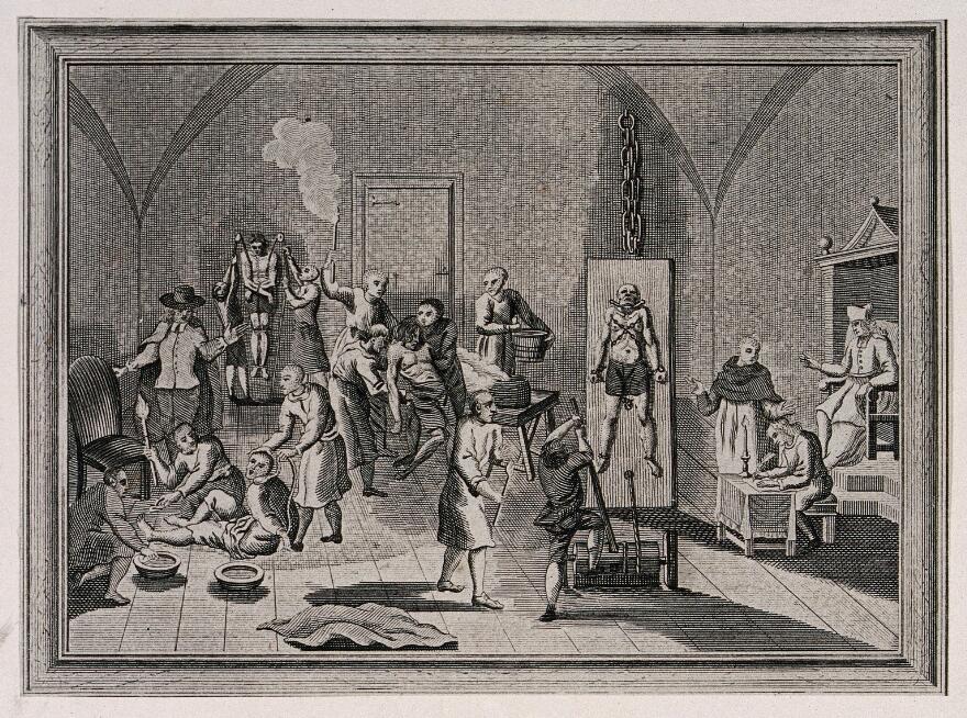 The inside of a jail of the Spanish Inquisition, with a priest supervising his scribe while men and women are suspended from pulleys, tortured on the rack or burnt with torches.