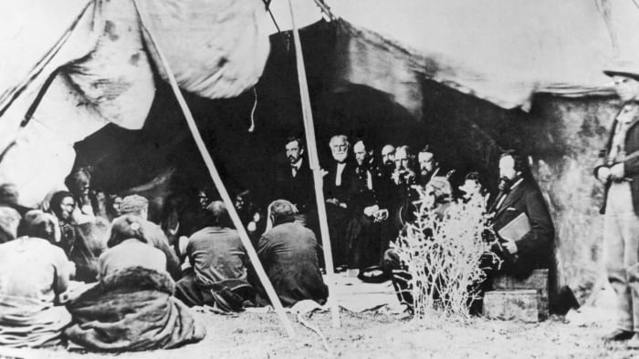 The signing of a treaty between William T. Sherman and the Sioux in a tent at Fort Laramie, Wyoming, 1868.